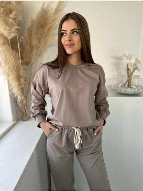 Rugalmas anyagú melegítőszett. Lenge, elöl rövid, hátul hosszú felső, magas, gumis derekú, megkötős nadrággal. (S-XL méretre ajánljuk.)