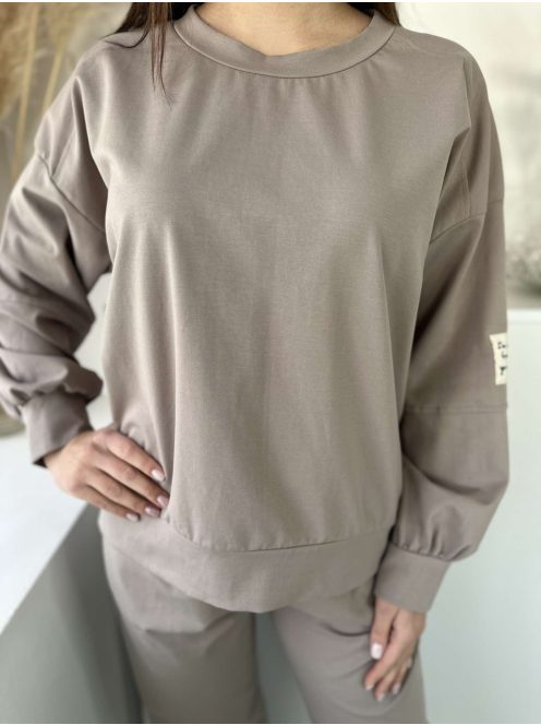 Rugalmas anyagú melegítőszett. Lenge, elöl rövid, hátul hosszú felső, magas, gumis derekú, megkötős nadrággal. (S-XL méretre ajánljuk.)