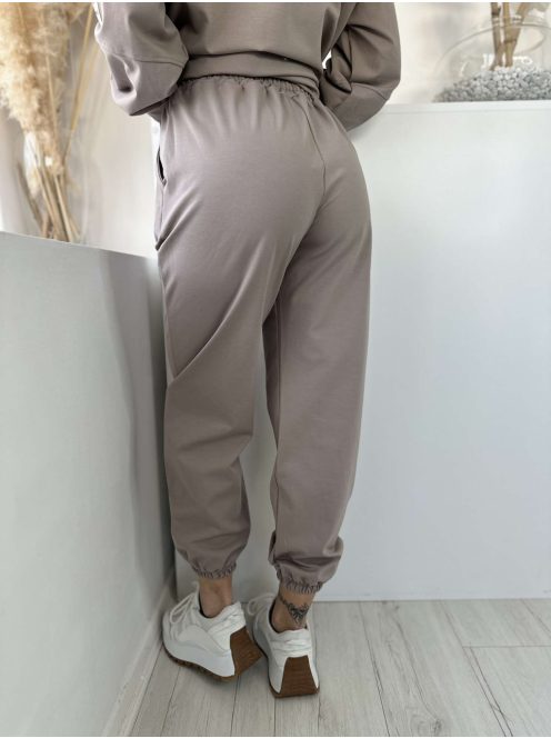 Rugalmas anyagú melegítőszett. Lenge, elöl rövid, hátul hosszú felső, magas, gumis derekú, megkötős nadrággal. (S-XL méretre ajánljuk.)