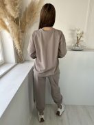 Rugalmas anyagú melegítőszett. Lenge, elöl rövid, hátul hosszú felső, magas, gumis derekú, megkötős nadrággal. (S-XL méretre ajánljuk.)