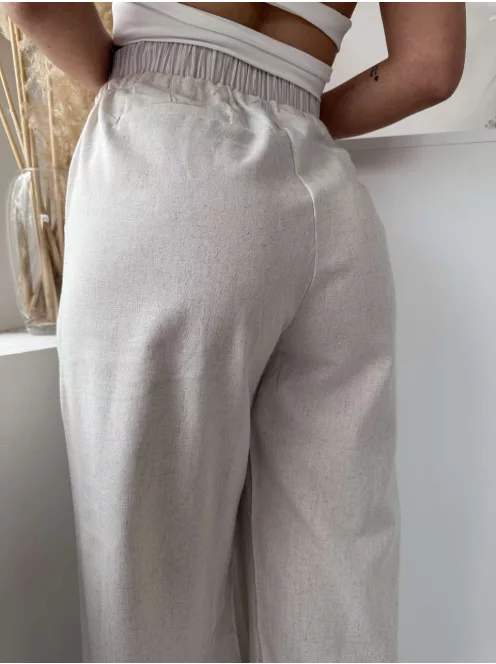 Lenvászon hatású, magas, gumis derekú, nem rugalmas anyagú, lenge fazonú, zsebes nadrág. A Modell S/M méretet visel. (S/M és L/XL méretekben.)