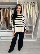 Rugalmas, puha, kötött szett. Magas, gumis derekú, egyenes szárú nadrág, lenge, felsliccelt felsővel. A Modell S/M méretet visel.