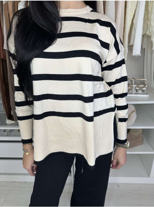 Rugalmas, puha, kötött szett. Magas, gumis derekú, egyenes szárú nadrág, lenge, felsliccelt felsővel. A Modell S/M méretet visel.