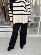 Rugalmas, puha, kötött szett. Magas, gumis derekú, egyenes szárú nadrág, lenge, felsliccelt felsővel. A Modell S/M méretet visel.