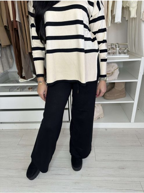 Rugalmas, puha, kötött szett. Magas, gumis derekú, egyenes szárú nadrág, lenge, felsliccelt felsővel. A Modell S/M méretet visel.