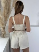 Lenvászon hatású, nem rugalmas anyagú szett. Rövid derekú, díszgombos, hátán gumírozott, magas, gumis derekú, zsebes rövidnadrággal. A Modell S/M méretet visel.