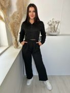 Kétrészes melegítő szett. Nem rugalmas anyagú, rövid, gumis derekú, kapucnis kardigán, magas, gumis derekú, zsebes nadrággal. A Modell S/M méretet visel. (S/M, L/XL és 2XL/3XL méretekben.)