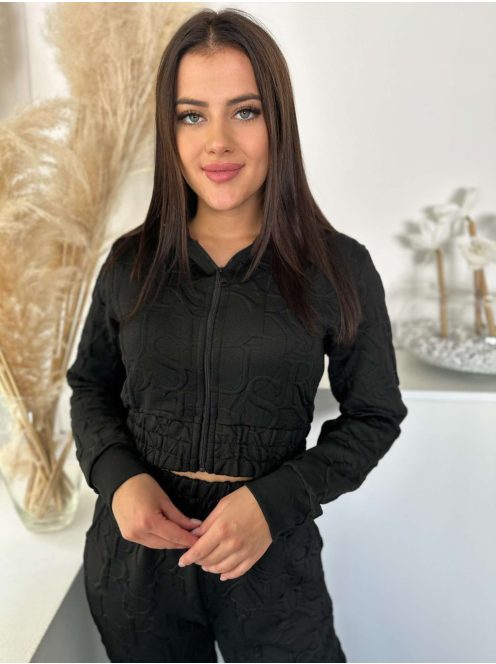 Kétrészes melegítő szett. Nem rugalmas anyagú, rövid, gumis derekú, kapucnis kardigán, magas, gumis derekú, zsebes nadrággal. A Modell S/M méretet visel. (S/M, L/XL és 2XL/3XL méretekben.)