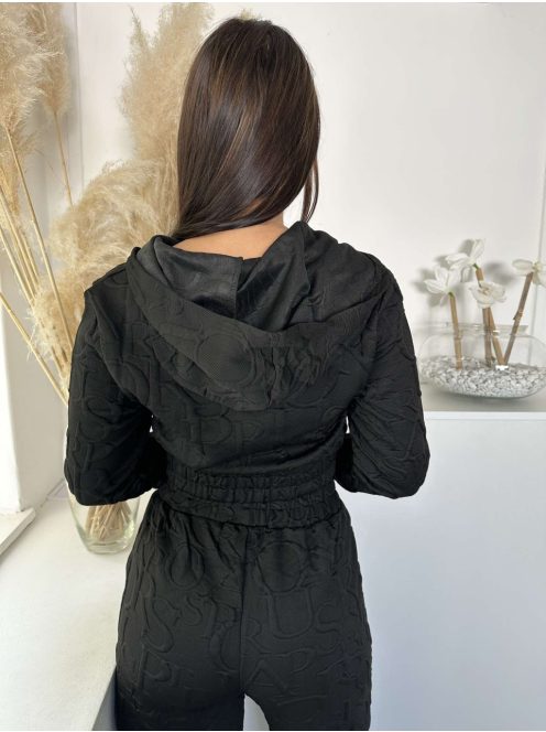 Kétrészes melegítő szett. Nem rugalmas anyagú, rövid, gumis derekú, kapucnis kardigán, magas, gumis derekú, zsebes nadrággal. A Modell S/M méretet visel. (S/M, L/XL és 2XL/3XL méretekben.)