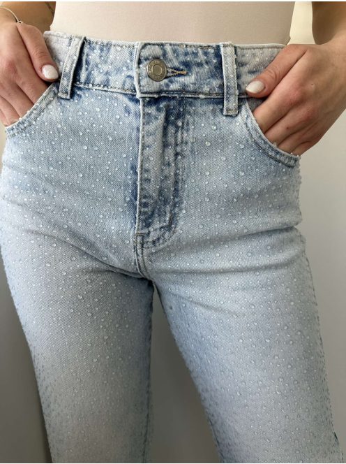 Magas derekú, kövekkel díszített, nem rugalmas anyagú, egyenes szárú, zsebes farmernadrág. A Modell S méretet visel. (XS-XL méretekben.)