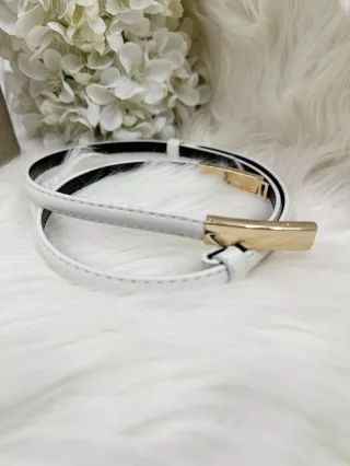 Műbőr, vékony, állítható fémcsatos öv.