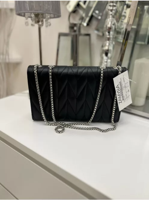 Műbőr, merev fazonú, patentos, állítható pántú, kis méretű táska.