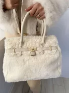 Puha szőrmés, merevebb fazonú táska, műbőr pánttal.