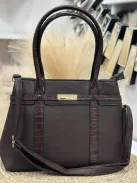 Műbőr, merev fazonú táska, levehető hosszúpánttal.