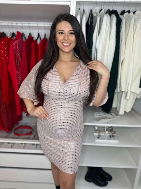 Csillogós, A vonalú, V kivágású, hátán cipzáras, nem rugalmas, alkalmi ruha. A Modell 36-os méretet visel.