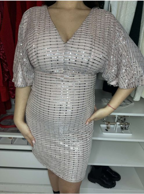 Csillogós, A vonalú, V kivágású, hátán cipzáras, nem rugalmas, alkalmi ruha. A Modell 36-os méretet visel.