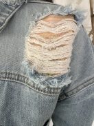 Oversize fazonú, szaggatott, gombos, zsebes, nem rugalmas farmerdzseki. A Modell S méretet visel. (S, M és L méretekben.)