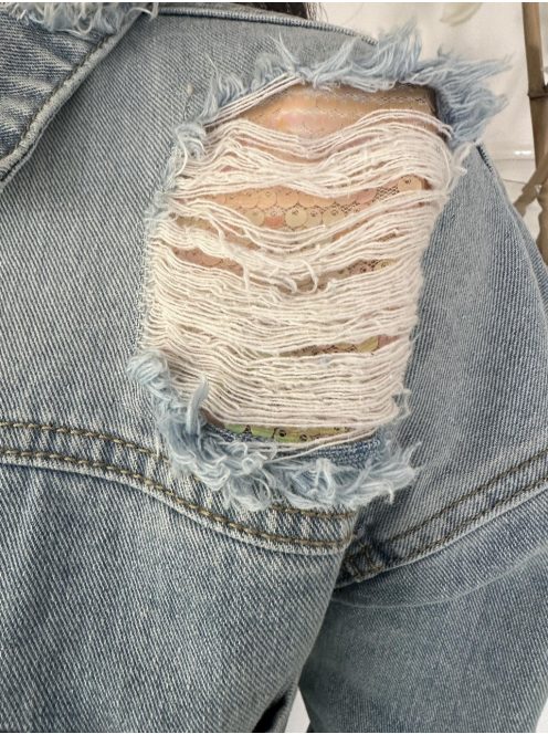 Oversize fazonú, szaggatott, gombos, zsebes, nem rugalmas farmerdzseki. A Modell S méretet visel. (S, M és L méretekben.)