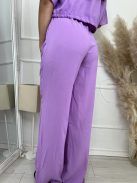 Nem rugalmas anyagú, lenge fazonú szett. Rövid derekú, megkötős, gombos felső rész, magas, gumis derekú, zsebes nadrággal. A Modell M méretet visel. (M, L és XL méretekben.)