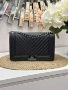 Merev fazonú, műbőr, láncos pántú táska. Szélesség: 28 cm Magasság: 18 cm.