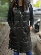 Bélelt, fényes, nem rugalmas anyagú, zsebes, cipzáras, kapucnis mellény. A Modell S méretet visel. (S-XXL méretekben.)